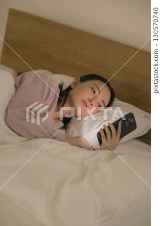 A woman watching a smartphone in bed 130570740