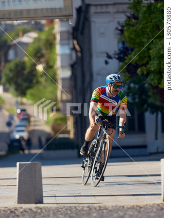Cyclist turning on city street with energy and control Cyclist turning on city street with energy and control 130570880