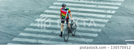 Cyclist walking with road bike on pedestrian crosswalk in city. Banner 130570912