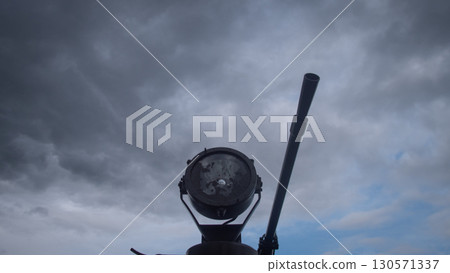 A cannon stands prominently against a turbulent sky, illustrating the gravity of conflict in Russia. Dark clouds loom overhead, hinting at the tension of war, while the cannon is ready for action. 130571337