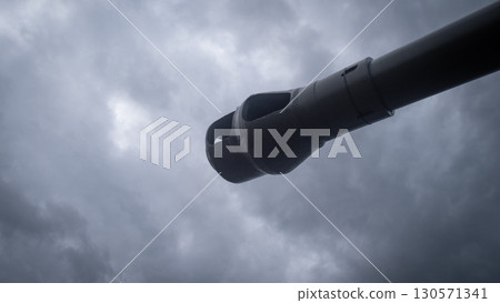Amidst a turbulent sky, a cannon stands ready as clouds gather overhead, setting a somber tone of conflict and anticipation in war-torn Russia. 130571341