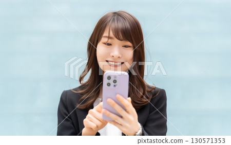 Smiling woman/businesswoman using a smartphone 130571353