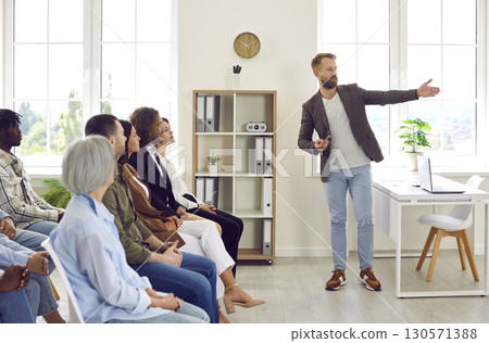Professional business coach making a presentation for a diverse audience in the office Professional business coach making a presentation for a diverse audience in the office 130571388