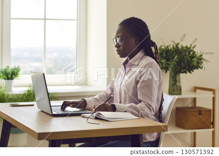 African american business woman accountant working on a laptop at office. African american business woman accountant working on a laptop at office. 130571392