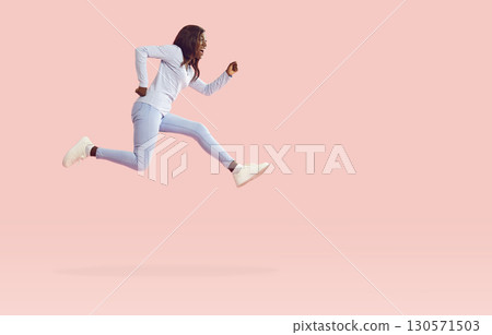 Funny happy woman wearing casual clothes jumping isolated on studio pink background. 130571503