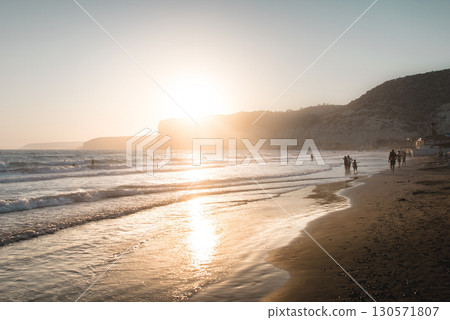 Tourists walking on Kourion beach at sunset in Cyprus 130571807