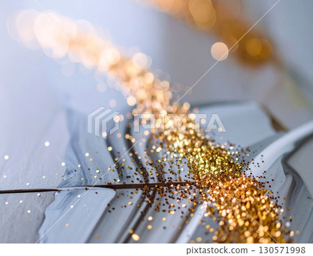 Golden Glitter Cascade on Textured Gray Surface with Bokeh in Bright Abstract Lighting 130571998