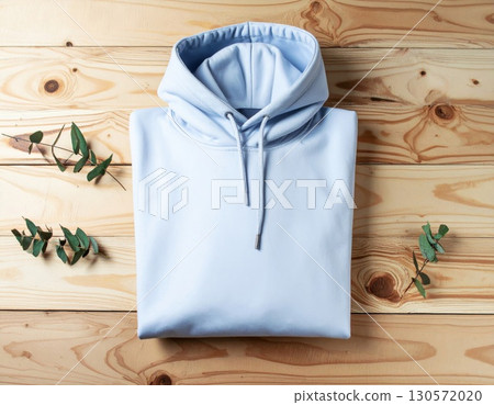 Light Blue Hoodie on Wooden Surface with Eucalyptus Leaves Flat Lay 130572020