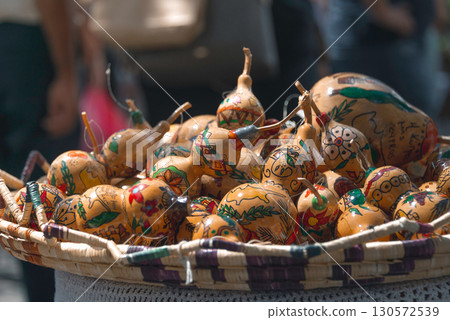 Traditional hand-painted Cypriot gourds nestled in woven basket, highlighting artisan craftsmanship and history 130572539