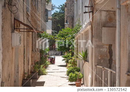 Potted greenery lining narrow passage between aged stone structures in historic famagusta, cyprus 130572542