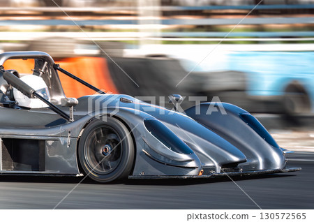 Race car speeding on a racetrack during a professional competition, motion blur on background 130572565
