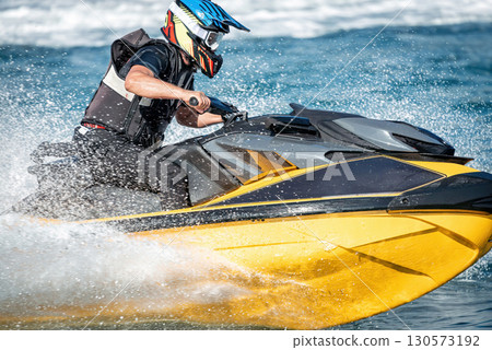 Pilot is riding a yellow watercraft on a sunny day Pilot is riding a yellow watercraft on a sunny day 130573192