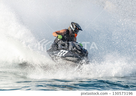 Professional jet ski racer is jumping on water surface at high speed Professional jet ski racer is jumping on water surface at high speed 130573196
