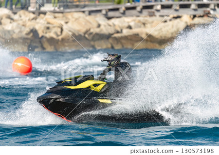 Pilot riding a watercraft at high speed on the sea during a competition 130573198