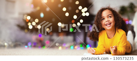 Dreamy african child writing wishlist for Christmas holidays, empty space 130573235