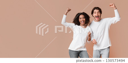 Yes. Overjoyed interracial couple celebrating success with raised fists, posing together over yellow background with empty space Yes. Overjoyed interracial couple celebrating success with raised fists, posing together over yellow background with empty space 130573494