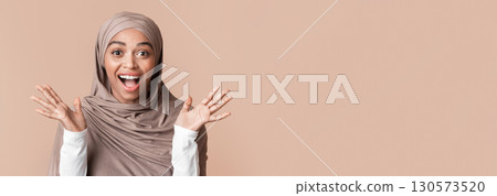 Portrait of excited black muslim woman in hijab exclaiming in amazement, experiencing happy shock over yellow background with free space Portrait of excited black muslim woman in hijab exclaiming in amazement, experiencing happy shock over yellow background with free space 130573520