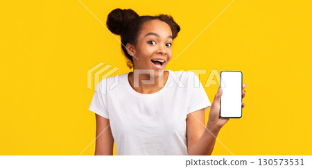 New Application. Cheerful african american girl showing cell phone with blank black screen. Panorama 130573531
