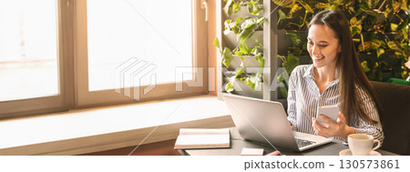 Young beautiful woman searching information in internet via laptop for creating business plan in cafe, free space Young beautiful woman searching information in internet via laptop for creating business plan in cafe, free space 130573861