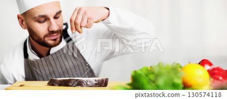 Food Seasoning. Chef Man Salting Fresh Fish Cooking Food Working In Restaurant Kitchen Indoor. Selective Focus 130574118