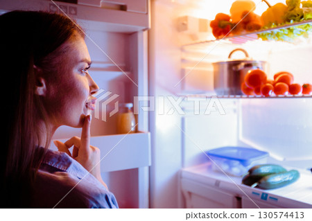 What do i want. Pensive girl looking into refrigerator for late snack, free space What do i want. Pensive girl looking into refrigerator for late snack, free space 130574413
