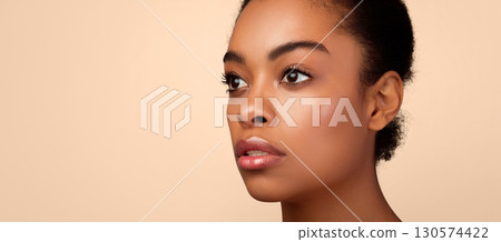 Portrait of sensual african young lady looking aside posing on gray background. Studio shot. Side view female headshot. Panorama with free space for your text. Facial skincare concept 130574422