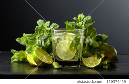 Mojito with ice, lime, and mint on a black background. 130574439