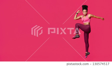 Active fitness afro girl making work out, warming up body before training, red background 130574517
