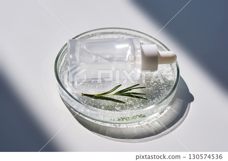 Antioxidant serum and rosemary in a petri dish. 130574536