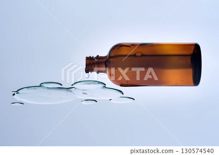 A bottle of cosmetic product with a serum texture. View from below. A bottle of cosmetic product with a serum texture. View from below. 130574540