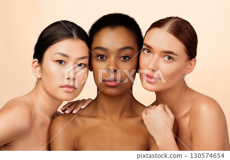 Beauty. Portrait Of Three Mixed Girls Looking At Camera Posing Naked Over White Background. Studio Shot Beauty. Portrait Of Three Mixed Girls Looking At Camera Posing Naked Over White Background. Studio Shot 130574654