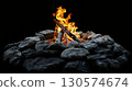 Close-up of a camp fire with vivid orange flames against a black background, ideal for fire and adventure visuals. 130574674