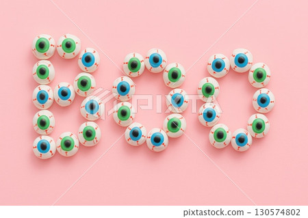 Spooky Halloween Typography Text "Boo" Pink Background Candy Eyeballs Minimalist Design Creepy Concept Festive Decoration 130574802