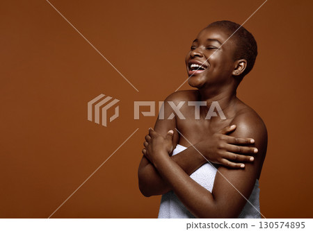 Chherful Beautiful Black Lady Standing With Folded Arms Wrapped In Towel After Bath, Cute African American Female With Short Hair Enjoying Her Natural Beauty, Posing Over Brown Background, Copy Space 130574895