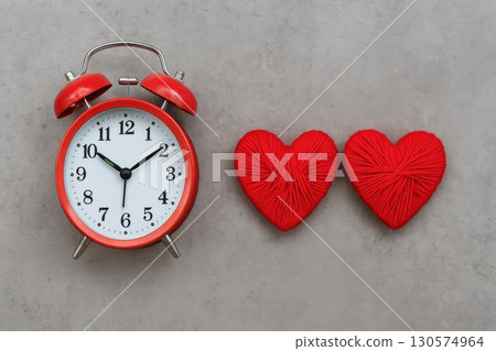 Romantic Time Symbolism Red Vintage Alarm Clock with Heart-Shaped Yarn Minimalist Concrete Setting Love and Punctuality 130574964