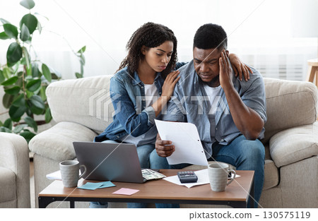 Family Financial Crisis Concept. Depressed Black Couple Looking At Invoice, Not Able To Pay Huge Bills, Suffering From Coronacrisis At Home 130575119