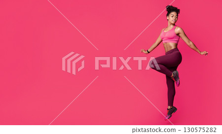Attractive sporty black girl exercising over red studio background 130575282