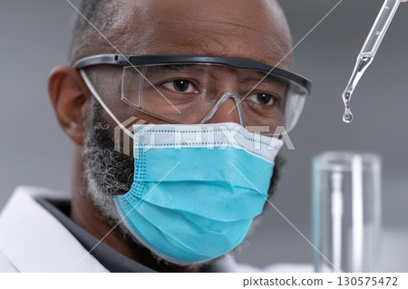 Scientist conducts experiment in laboratory with pipette and test tube during research process 130575472
