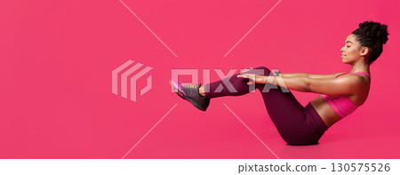 Young sporty afro woman practicing over red background doing crisscross exercise, bicycle crunches pose sitting on floor, copy space 130575526