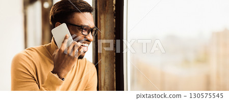 Calling Family. Close up portrait of happy african student making phone call to his relatives or girlfriend. Free space Calling Family. Close up portrait of happy african student making phone call to his relatives or girlfriend. Free space 130575545