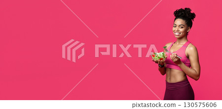 Healthy food concept. Happy African American Fitness Girl Eating Vegetable Salad, red studio background, copy space Healthy food concept. Happy African American Fitness Girl Eating Vegetable Salad, red studio background, copy space 130575606