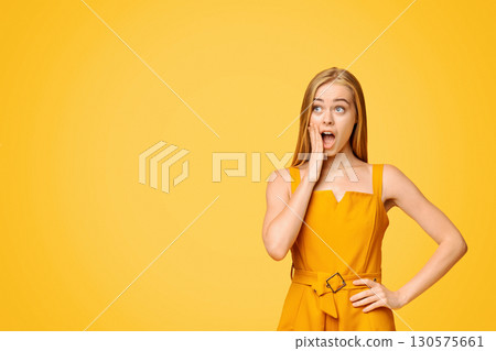 OMG. Shoked Young Girl Looking At Copy Space And Touching Face With Amazement, Standing Over Yellow Background, Panorama 130575661