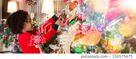 Xmas tradition. Cute little african american girl decorating Christmas tree at home, panorama Xmas tradition. Cute little african american girl decorating Christmas tree at home, panorama 130575675