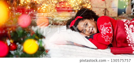 Adorable little black girl lying near Christmas tree, waiting for Santa with Xmas presents 130575757