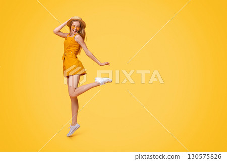 Carefree Youth. Full-Length Portrait Of Positive Teen Girl Jumping Over Yellow Studio Background, Free Space 130575826