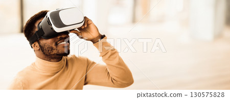 VR Technology. Black man wearing virtual reality glasses experiencing innovative technology, copy space 130575828