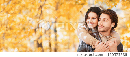 Woman in love hugging her handsome man from behind, one day at autumn forest, panorama with copy space Woman in love hugging her handsome man from behind, one day at autumn forest, panorama with copy space 130575886