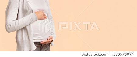 Unrecognizable Pregnant Woman Touching Belly Posing In Studio Over White Background. Panorama, Copy Space, Cropped 130576074
