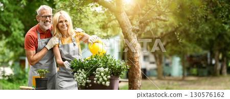 Happy Mature Gardeners Couple In Aprons Tending To Plants In Backyard, Loving Senior Spouses Watering Flowers And Smiling At Camera, Older Man And Woman Enjoying Retirement Leisure, Copy Space Happy Mature Gardeners Couple In Aprons Tending To Plants In Backyard, Loving Senior Spouses Watering Flowers And Smiling At Camera, Older Man And Woman Enjoying Retirement Leisure, Copy Space 130576162