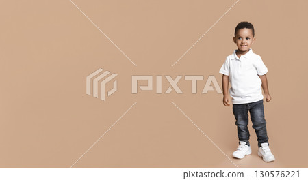 Portrait of cute little black baby boy standing in studio over yellow background, free space Portrait of cute little black baby boy standing in studio over yellow background, free space 130576221
